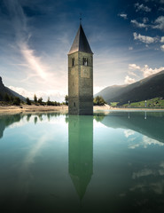 Obraz premium Versunkene Kirche ragt aus dem grünen Reschensee