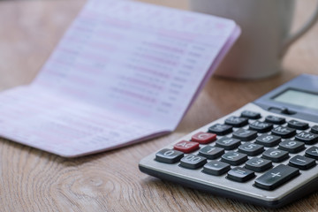 Obraz premium calculator, bankbook ,coffee cup Put on a wooden table.