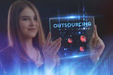 The concept of business, technology, the Internet and the network. A young entrepreneur working on a virtual screen of the future and sees the inscription: Outsourcing