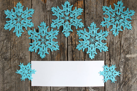 Blue crochet snowflakes on vintage wooden background, white space for your lettering. Open opportunities for your project. Festive Christmas mood, new year.