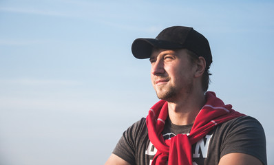 Young man looking forward against the blue sky background