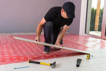 Handyman installing new laminated wooden floor