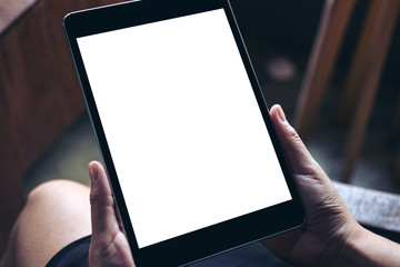 Mockup image of hands holding black tablet pc with blank white desktop screen