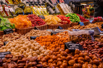 A market stall selling spiced nuts and dried, candied fruit snacks.