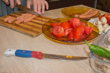 Hands cuts sausages with knife. Cooking process concept. Chef prepares meal. Cook, prepares eating...