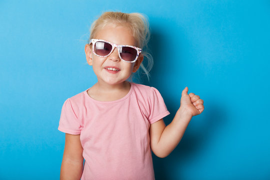 Blonde girl child in sunglasses. Attractive fashion kid.