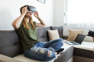 Beautiful young woman enjoying virtual reality at her home.