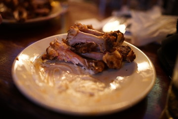 Chicken bones left over on an empty plate from a delicious meal