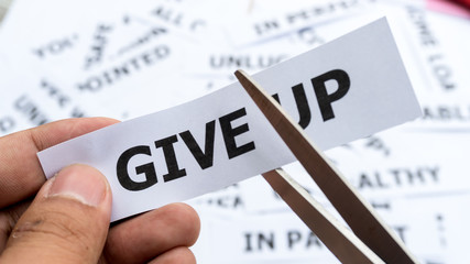 give up text or word meaning on paper in hand holding