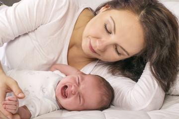 Obraz na płótnie Canvas Mother calming her crying baby girl 