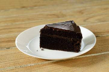 Delicious chocolate cake macro close up on white dish and wooden table backgrounds