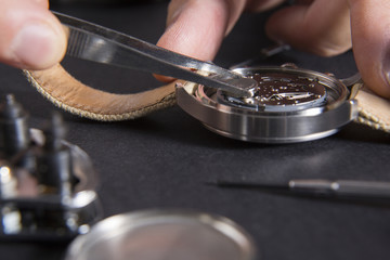 Detail of the work of a watchmaker who replaces a battery / Close up of replacing a watch battery...