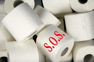Many rolls of white toilet paper. A matter of daily necessity with inscription S.O.S.Detail of...