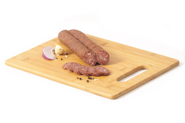 Cajna kobasica - Serbian style hard salami on cutting board isolated on white background