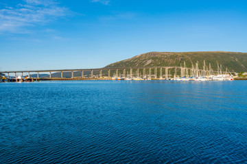 Fototapeta na wymiar View of Tromso Bridge across Tromsoysundet strait in Norway. It connects Tromso on island of Tromsoya with Tromsdalen on mainland