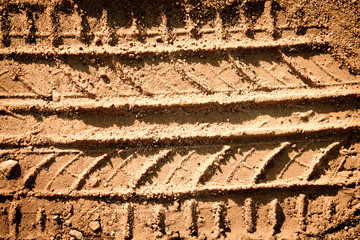 Tyre tracks texture on sand in brown tone