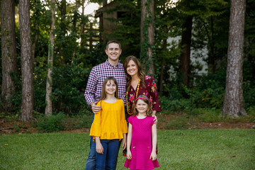 Fototapeta premium Nuclear Family of Four with Daughters Outside in their Backyard