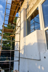 Insulation of the house with styrofoam. Scaffold on building