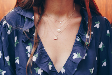 fashion blogger outfit details. fashionable woman wearing a gold chain necklace. detail of a...