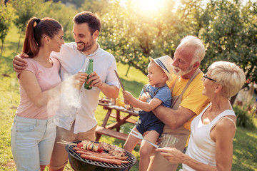 Happy family having barbecue party at summer garden