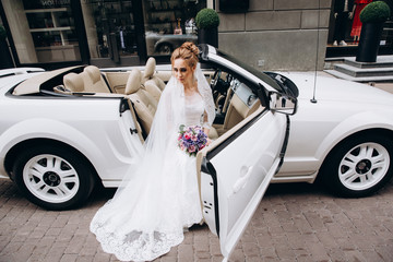 A bride in a white dress is holding a beautiful wedding bouquet.