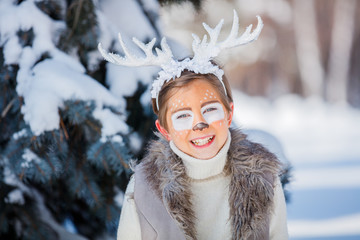Portrait of smiling boy with funny antlers of a deer. Holiday concept.