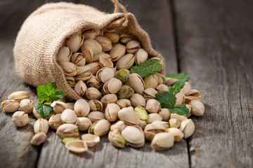 Sack with pistachios on a wooden table.