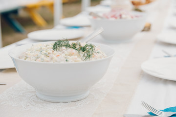 A bowl of Fresh potato salad on a table. 