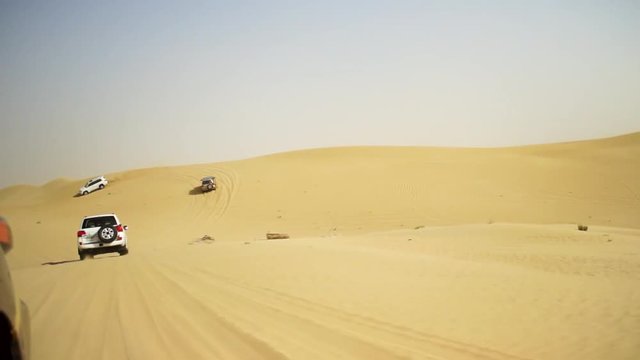 Desert Safari SUVs bashing through the arabian sand dunes. SUV tour through the Arabian desert