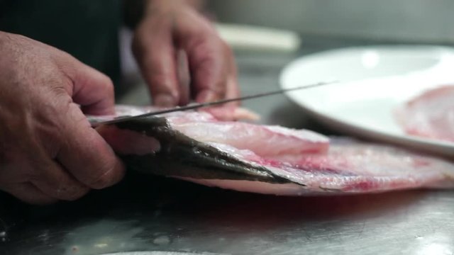 Filleting the golden fish in the restaurant