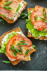 Mini toast of grain bread with tomatoes, bacon, lettuce and green onions