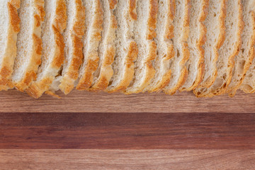 Close-up of sliced bread. Rustic looking on wooden board background. Slices of village white bread.