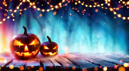 Foto auf Acrylglas Halloween-Party - Kürbisse und Lichterketten auf dem Tisch im dunklen Wald © Romolo Tavani