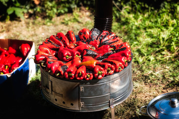 Fresh red peppers roasting over a grill - 223589803