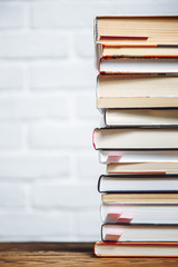 Stack of hardback books on wooden table. Back to school. Copy space for text