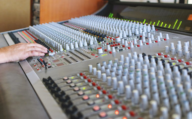 the sound engineer's hand on the analogue console's fader