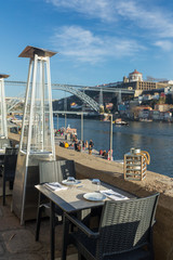 Cafe on the banks of the River Douro with a beautiful view at Ponte dom Luis bridge in Porto, Portugal