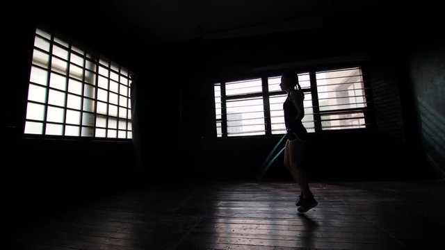 silhouette female boxer in wrapped bandage hands jumping on skipping rope in gym. Fit woman preparing to boxing competition. Wellness, fighting, motivation, martial arts, self defense concept