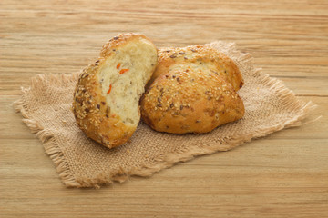 Bun with sesame and carrots on a linen cloth on a wooden background