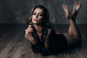 Naklejka premium beautiful sexy young blonde woman posing in black lace lingerie