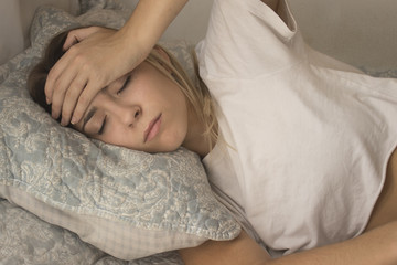 pretty young girl with headache in bed