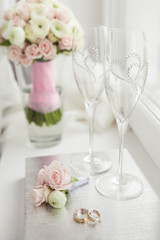 Wedding rings with flowers and glasses