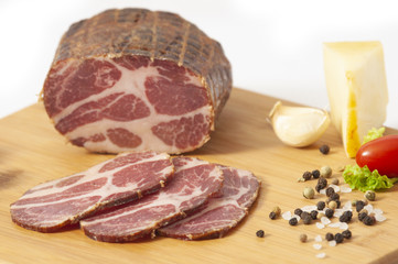 Hickory smoked pork shoulder - stuffed in net and sliced on cutting board