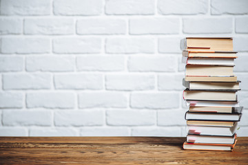 Stack of hardback books on wooden table. Back to school. Copy space for text