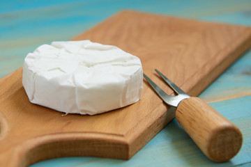 cheese camembert or brie on blue wooden background
