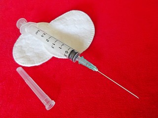 Medicine Medical Health Industry Transparent Plastic Syringe For Drugs Medicament Vaccine Injection Tool And White Cotton Circles On The Red Textile Cloth Velvet Background 