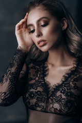 Fototapeta premium beautiful sexy young blonde woman posing in black lace lingerie