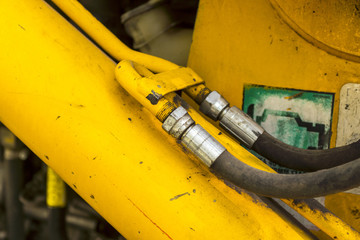 Old Hydraulic piston system for bulldozers, tractors, excavators, chrome plated cylinder shaft of yellow machine, construction heavy industry detail