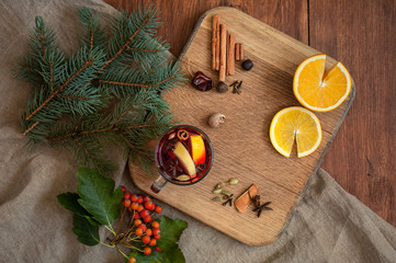 Top view mulled wine with citrus, cinnamon, cardamon and anise spices and fir. Christmas cozy...