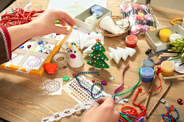 Fototapeta premium Childrens making decorations for new year holiday. Painting watercolors. Top view. Artwork workplace with creative accessories.